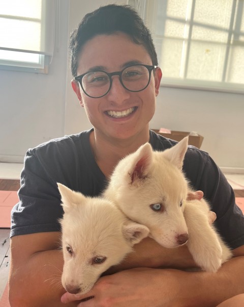 Benjamin Sofaer holding white hair puppies